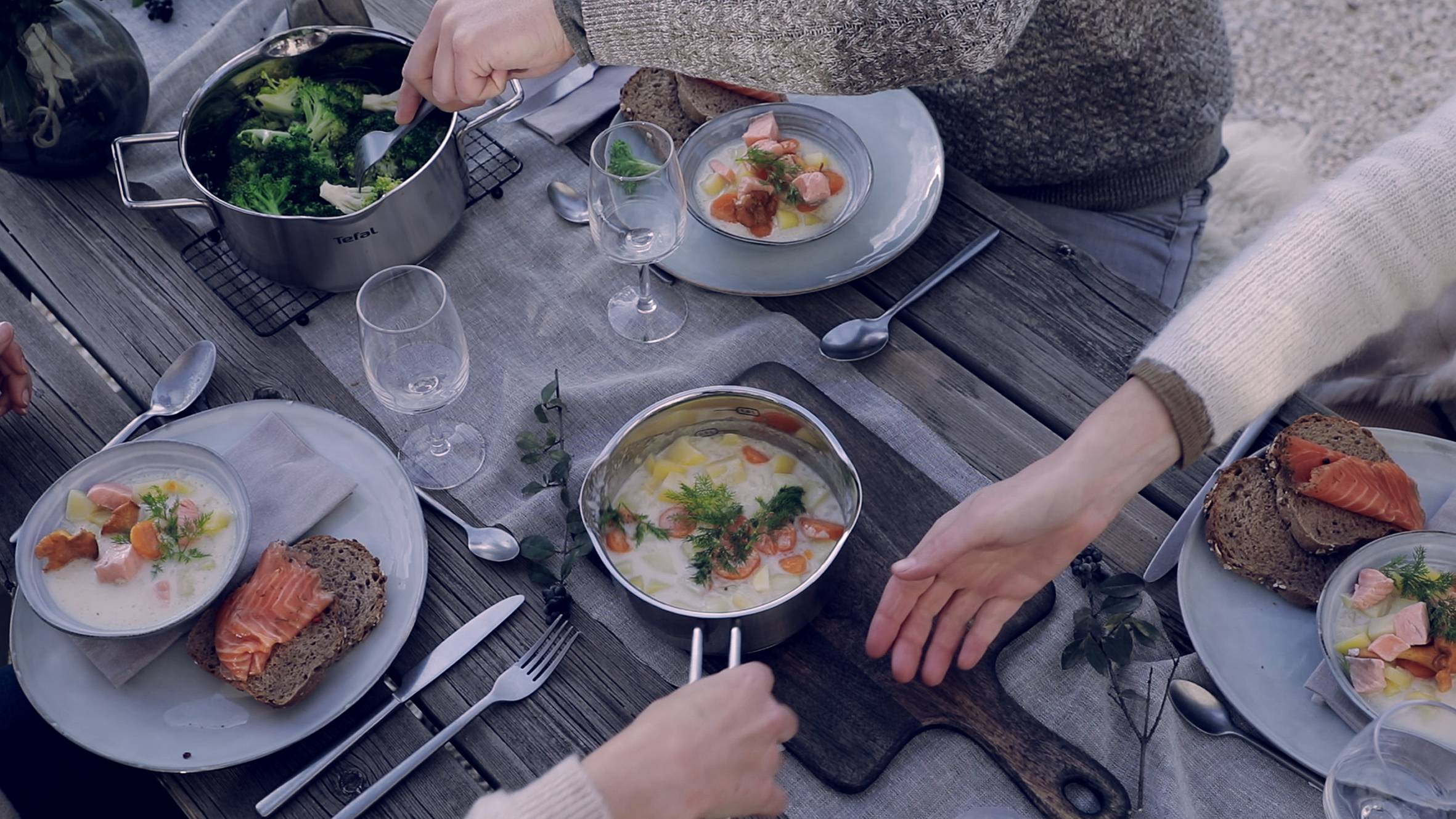 Gedeckter Esstisch mit frisch gekochtem Essen aus Tefal Edelstahltöpfen